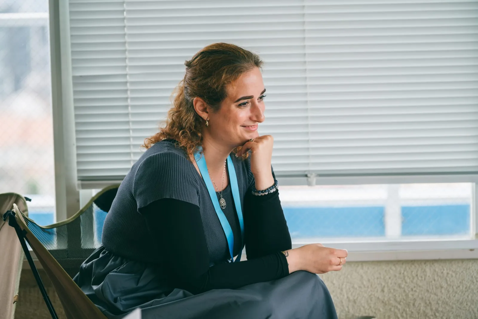 Close-up of Mirela Curiman smiling and listening during a Colive Fukuoka community event.