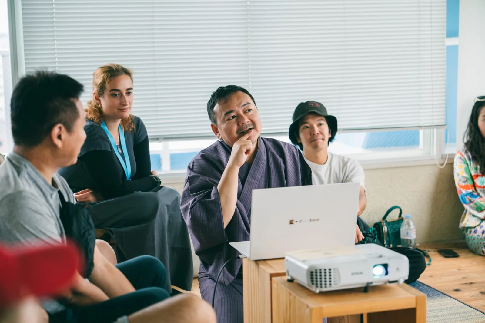 Mirela Curiman sitting among participants during a community workshop at Colive Fukuoka.
