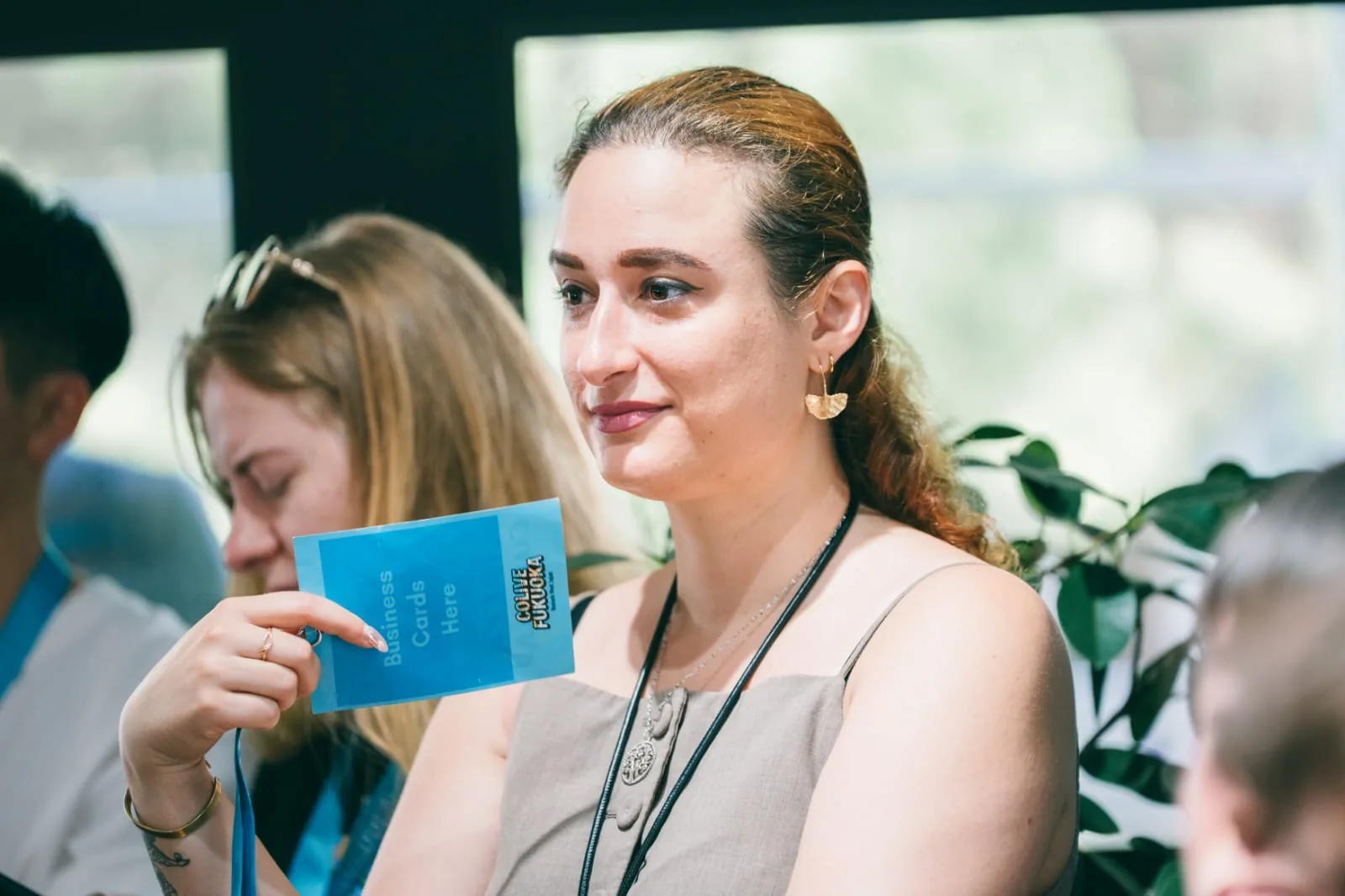 Mirela Curiman holding a Colive Fukuoka business card.