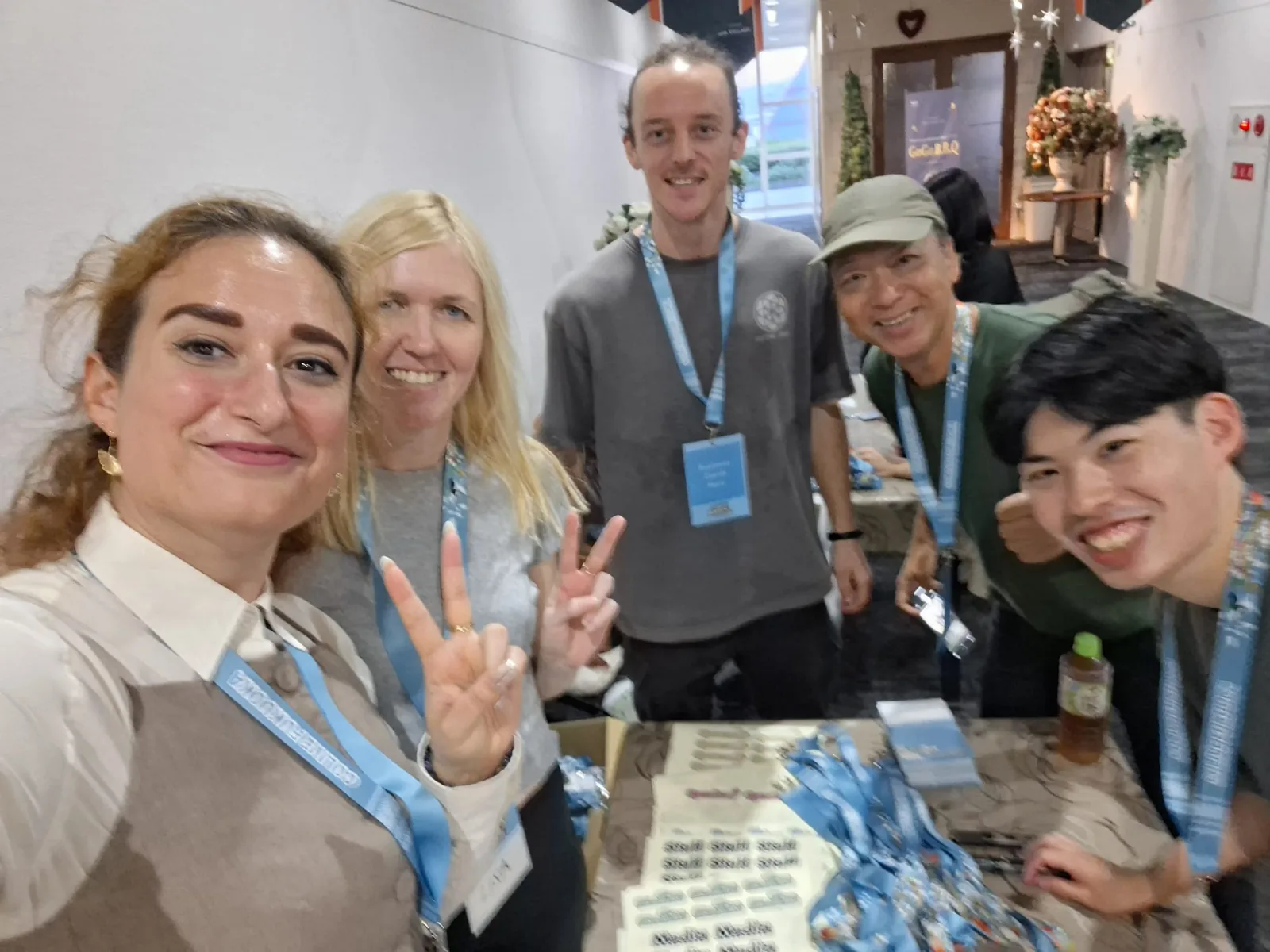 Mirela Curiman taking a selfie with the Colive Fukuoka volunteer team behind the registration desk.
